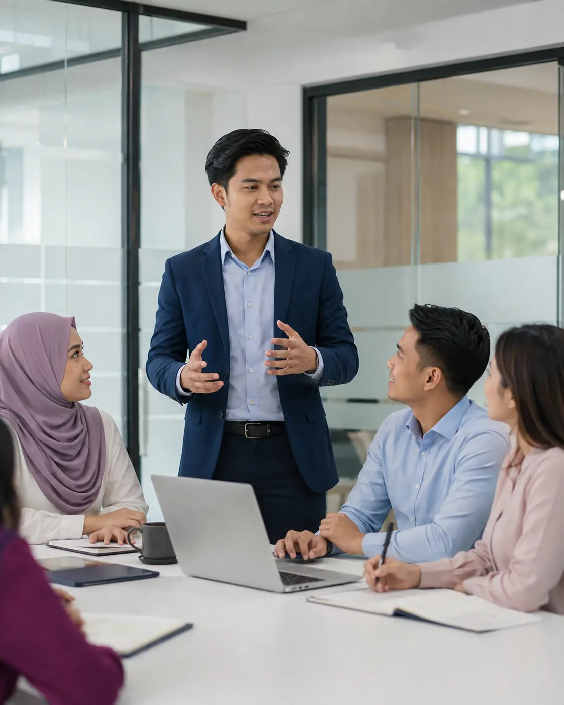 Malaysian professional speaking confidently during a meeting